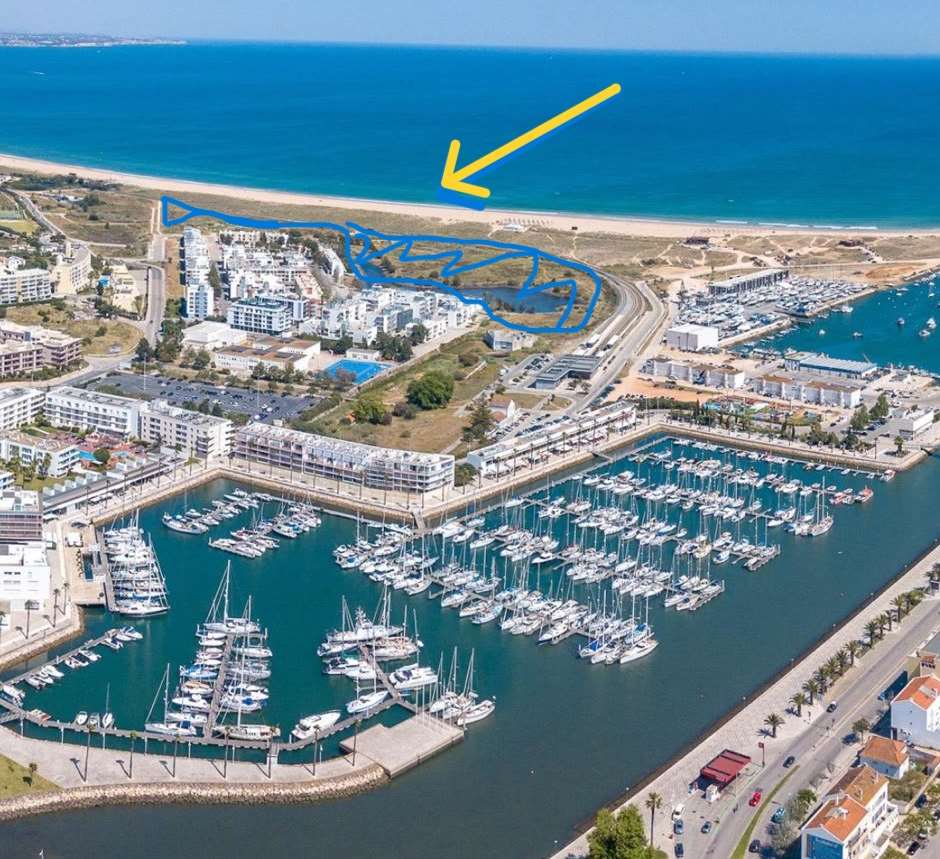 Aerial photograph of Meia Praia and Lagos marina with the proposed development area outlined in blue beside the beach